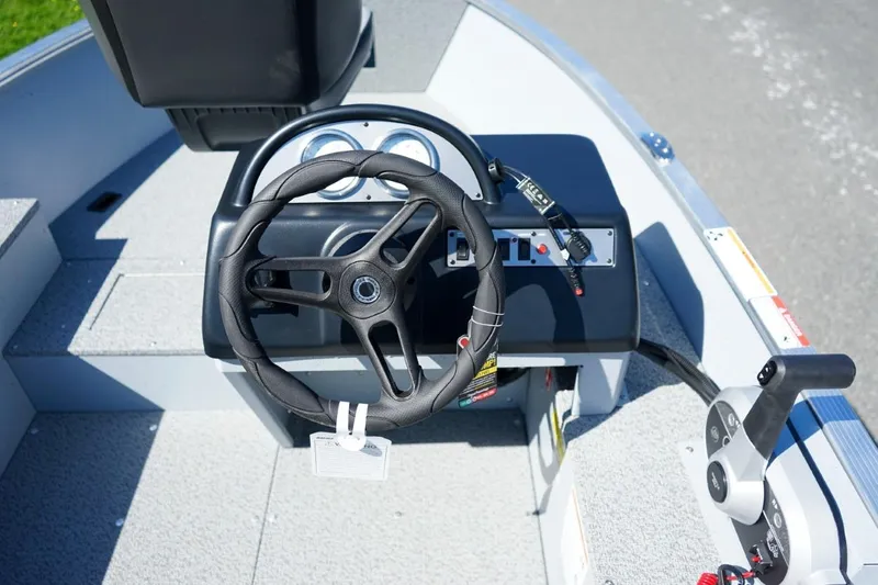 Slide: The Image of Steering console of 2026 Lund 1400 Fury SS boat, featuring modern controls and dashboard. - 6