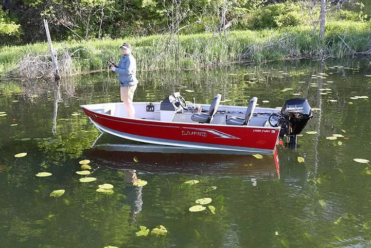 Slide: The Image of Manufacturer Provided Image: 2025 Lund 1400 Fury SS boat on a serene lake with lily pads. - 9