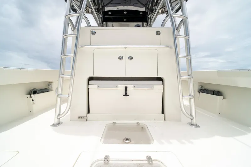 Slide: The Image of 2018 SeaVee 390Z boat deck with storage compartments and ladder under cloudy sky. - 25