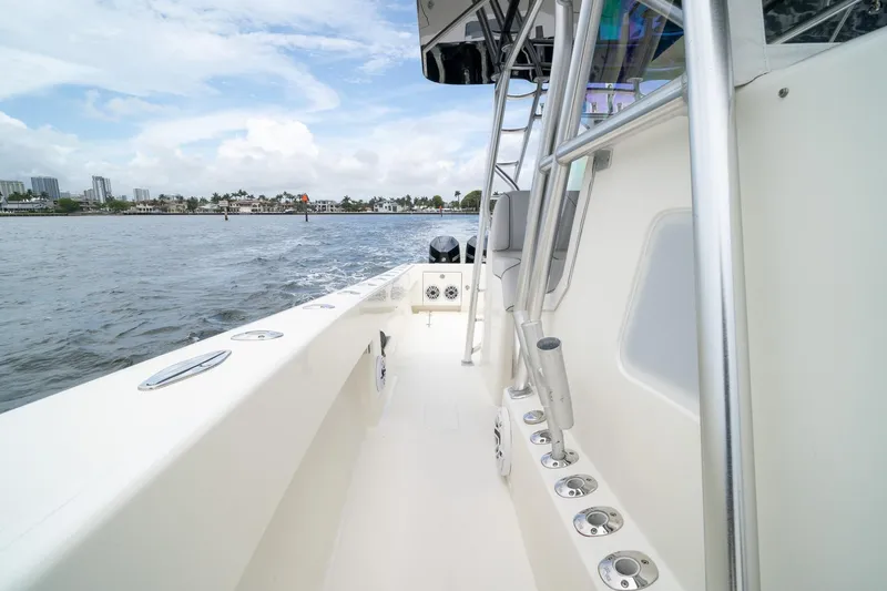 Slide: The Image of 2018 SeaVee 390Z boat cruising on a calm waterway with cityscape in background. - 60