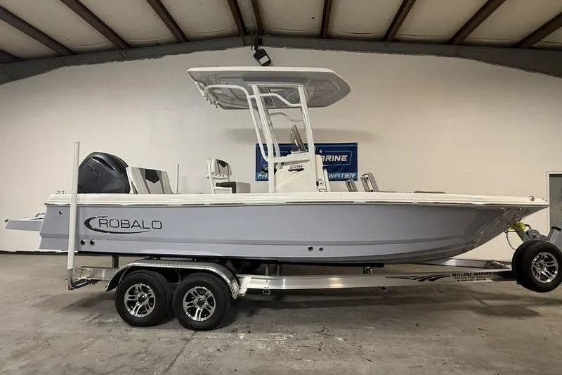 The Image of 2026 Robalo 226 Cayman boat on trailer in indoor showroom. - 0