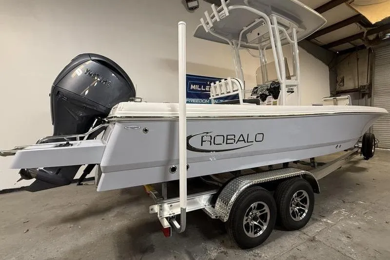 Slide: The Image of 2026 Robalo 226 Cayman boat on trailer in indoor storage. - 3