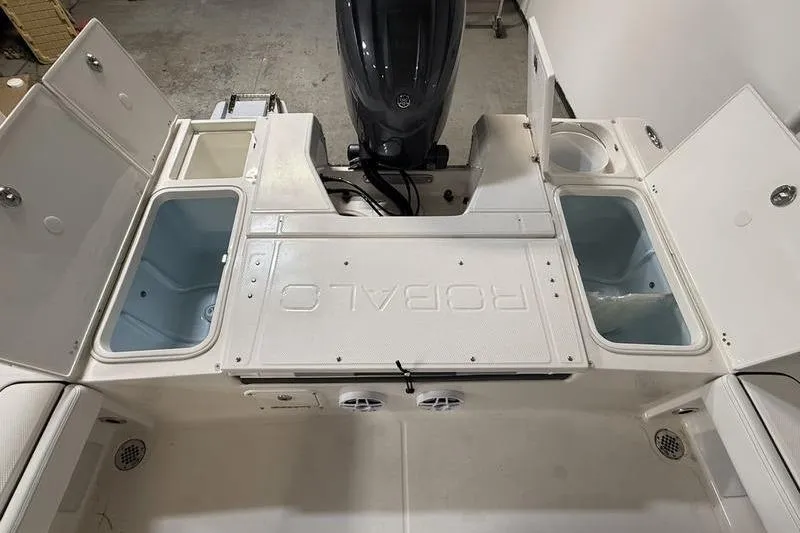 Slide: The Image of 2026 Robalo 226 Cayman boat deck with storage compartments and motor. - 6