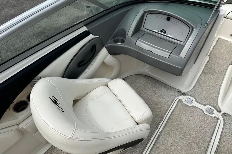 Slide: The Image of Interior of a 2008 Monterey 194FS boat featuring a white captain's chair and dashboard. - 12