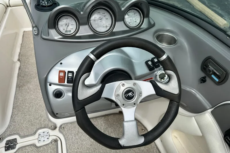 Slide: The Image of Steering wheel and dashboard of a 2008 Monterey 194FS boat, featuring gauges and controls. - 13