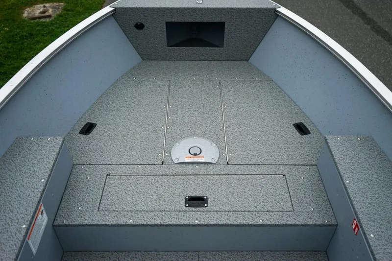 Slide: The Image of 2026 Lund 1400 Fury Tiller boat interior with gray textured flooring. - 12
