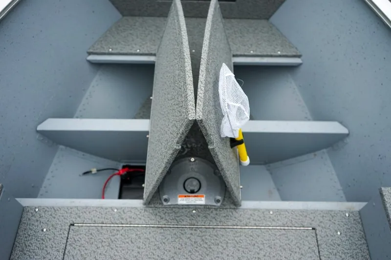 Slide: The Image of 2026 Lund 1400 Fury Tiller boat interior with storage compartments and fishing net. - 14