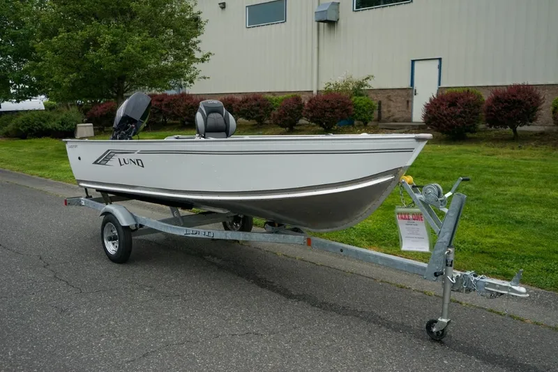 The Image of 2026 Lund 1400 Fury Tiller boat on trailer, parked outdoors near a building. - 5