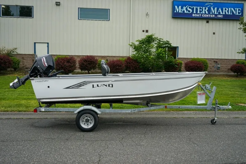 Slide: The Image of 2026 Lund 1400 Fury Tiller boat on trailer outside Master Marine Boat Center. - 6
