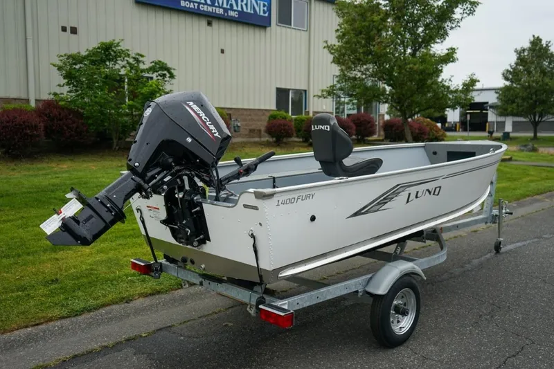 Slide: The Image of 2026 Lund 1400 Fury Tiller boat on trailer, featuring Mercury outboard motor. - 7