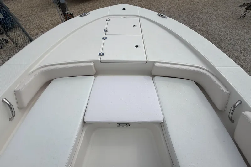 Slide: The Image of 2017 Robalo 246 Cayman boat interior with cushioned seating and storage compartments. - 6