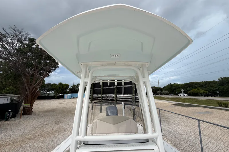 Slide: The Image of 2017 Robalo 246 Cayman boat with T-top, parked outdoors under cloudy skies. - 8