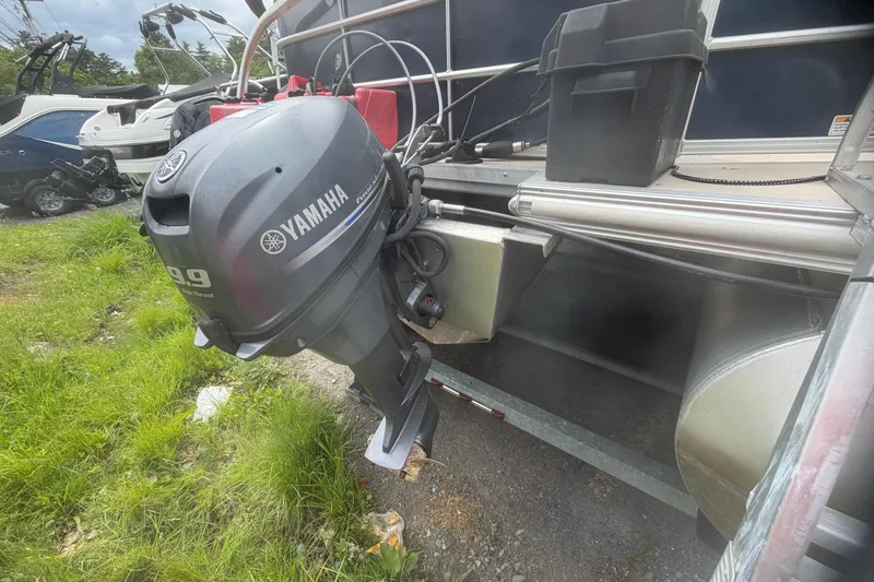 Slide: The Image of 2014 Sylvan Mirage Cruise 818 CR with Yamaha outboard motor in grassy area. - 13