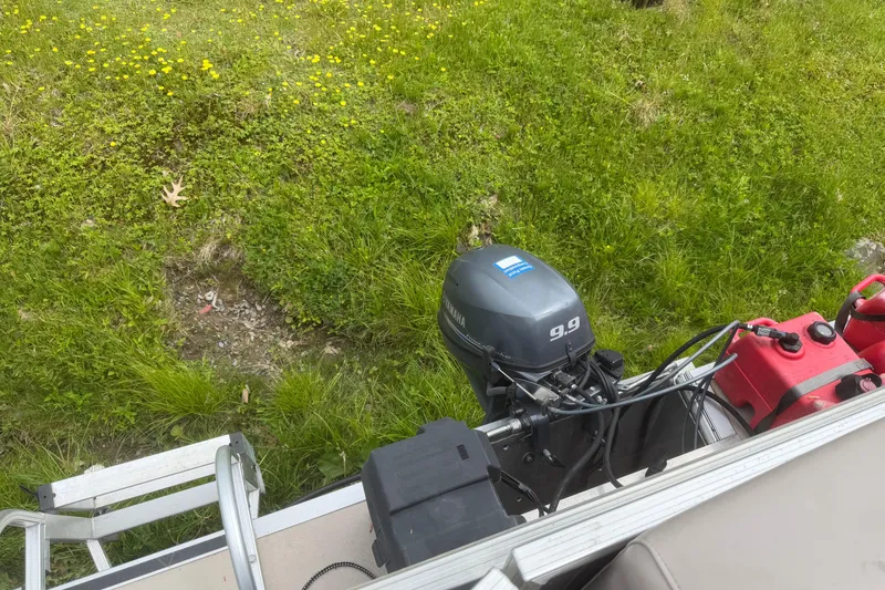 Slide: The Image of 2014 Sylvan Mirage Cruise 818 CR with Yamaha 9.9 motor, grassy background. - 14