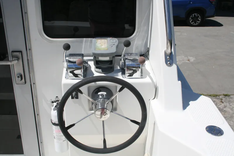 Slide: The Image of Steering console of a 2002 Sea Sport Explorer 2400 boat with navigation controls. - 1