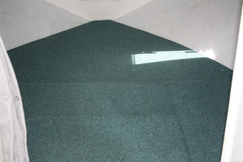 Slide: The Image of Interior cabin of 2002 Sea Sport Explorer 2400 with green carpet flooring. - 10