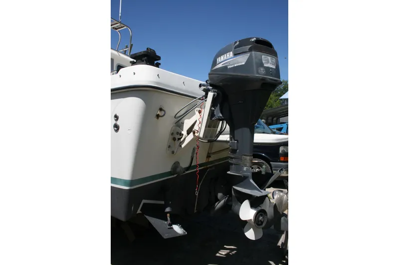 Slide: The Image of 2002 Sea Sport Explorer 2400 boat with Yamaha outboard motor, docked under clear blue sky. - 13