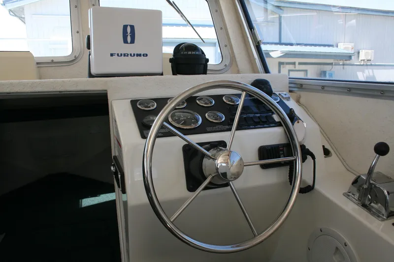 Slide: The Image of 2002 Sea Sport Explorer 2400 helm with steering wheel and navigation instruments. - 3