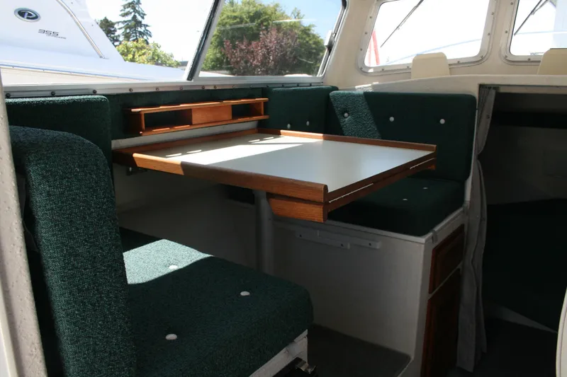 Slide: The Image of Interior of 2002 Sea Sport Explorer 2400 with green seating and wooden table. - 6