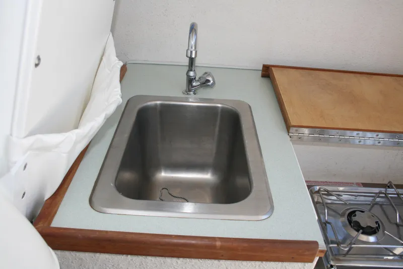 Slide: The Image of 2002 Sea Sport Explorer 2400 boat kitchen with stainless steel sink and stove. - 7