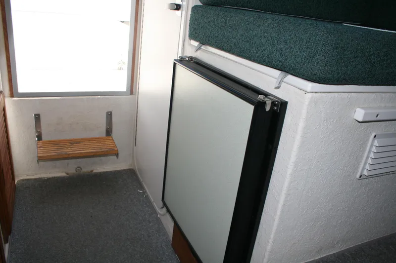 Slide: The Image of Interior of 2002 Sea Sport Explorer 2400, featuring a compact seating area and storage. - 8