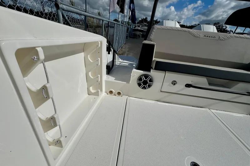 Slide: The Image of 2026 Navan S30 boat interior with storage compartment and seating area under a cloudy sky. - 14