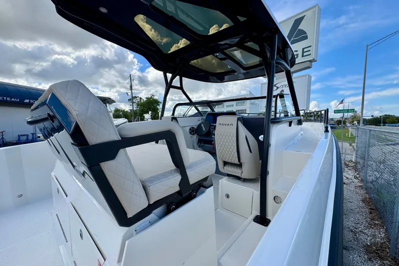 Slide: The Image of 2026 Navan S30 boat interior with modern seating and steering console under a blue sky. - 20
