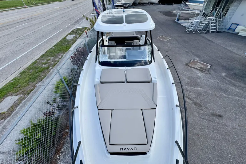 Slide: The Image of 2026 Navan S30 boat with sleek design, docked near a road and fence. - 57