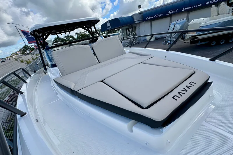 Slide: The Image of 2026 Navan S30 boat with cushioned seating, docked under a cloudy sky. - 59