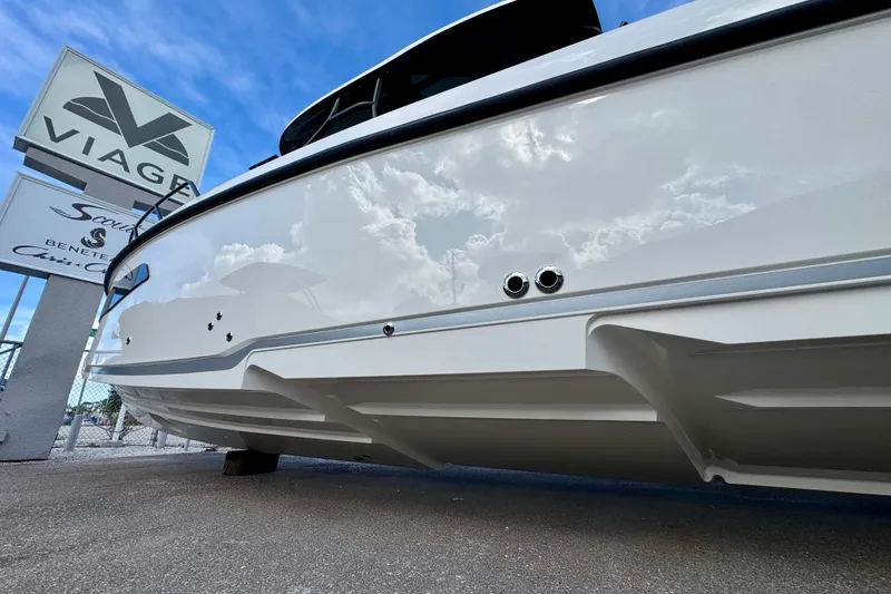 Slide: The Image of 2026 Navan S30 boat hull with Viage sign, reflecting cloudy sky. - 8