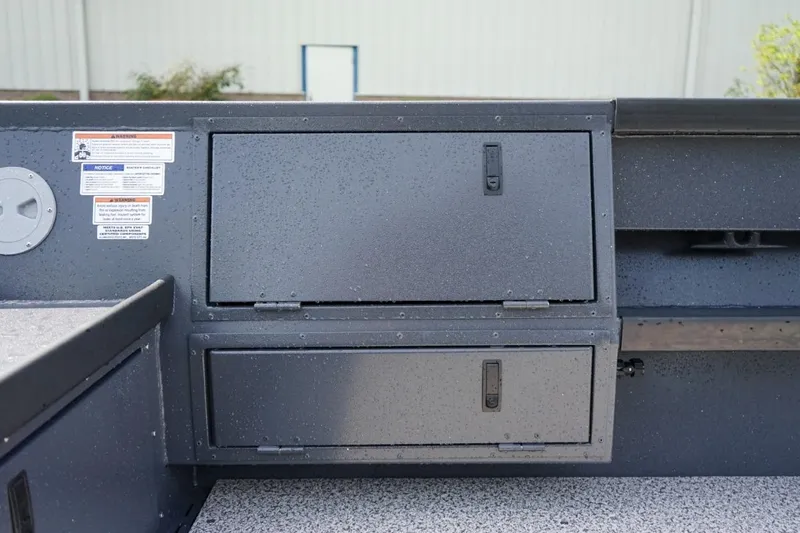 Slide: The Image of 2026 Alumaweld 23' Columbia boat storage compartments with safety labels. - 11