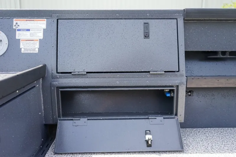 Slide: The Image of 2026 Alumaweld 23' Columbia boat storage compartments with safety labels. - 13