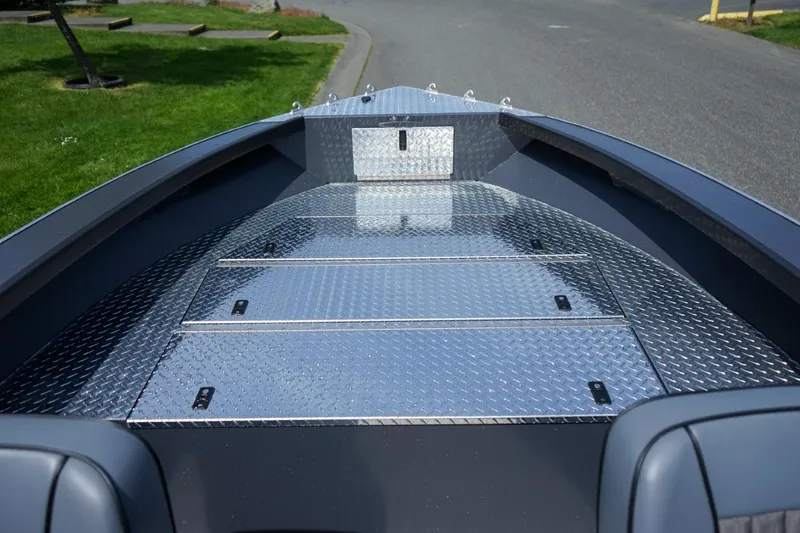 Slide: The Image of 2026 Alumaweld 23' Columbia boat deck with diamond plate flooring, parked on a street. - 17