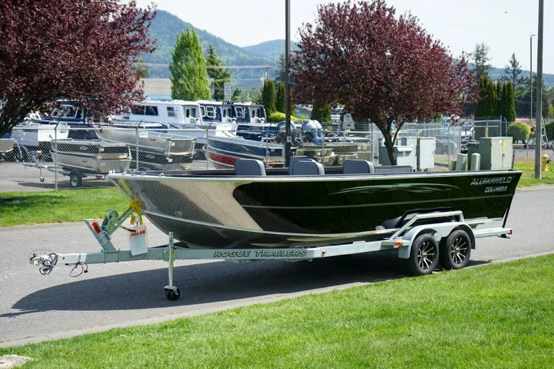 Slide: The Image of 2026 Alumaweld 23' Columbia boat on trailer, parked outdoors near other boats. - 22