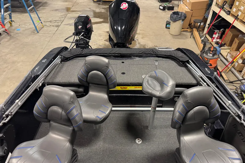 Slide: The Image of 2021 Nitro ZV19 Sport boat interior with gray seating and outboard motor in a garage. - 10
