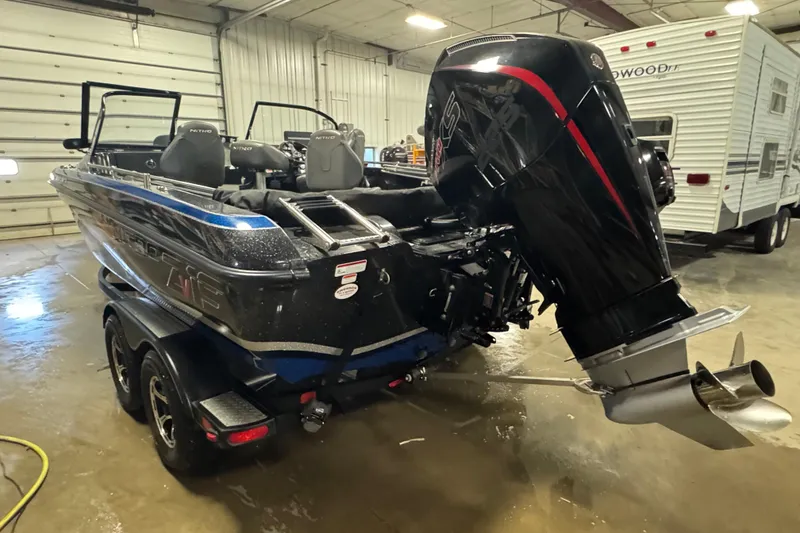 Slide: The Image of 2021 Nitro ZV19 Sport boat with powerful outboard motor in a garage setting. - 4