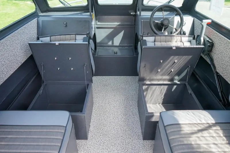 Slide: The Image of 2026 Alumaweld X202 Stryker boat interior with open storage compartments and steering wheel. - 16
