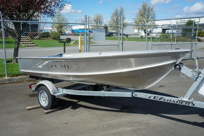 The Image of 2021 Lund WC-12 aluminum boat on EZ Loader trailer, parked outdoors. - 7