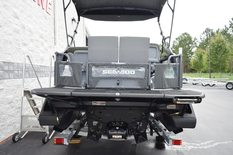 Slide: The Image of 2025 Sea-Doo Switch Fish 18 pontoon boat rear view, parked outdoors. - 6