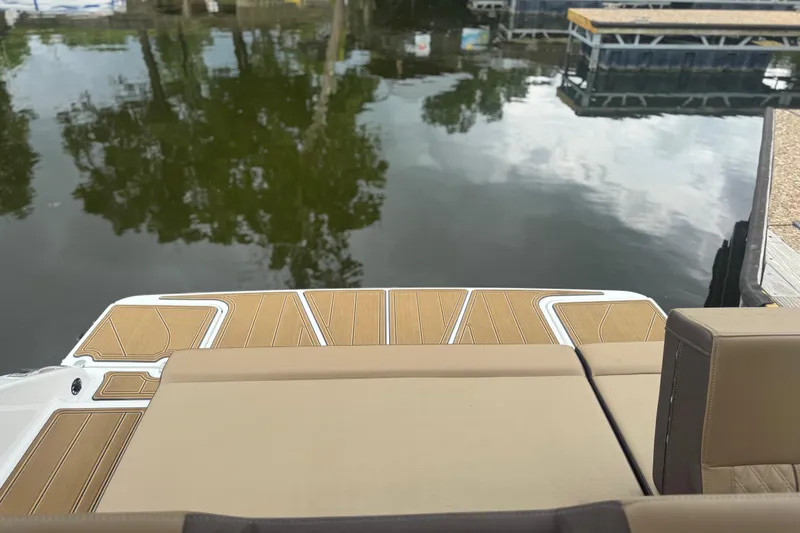 Slide: The Image of 2026 Monterey Elite 25 SD boat with tan seating and water reflection. - 10