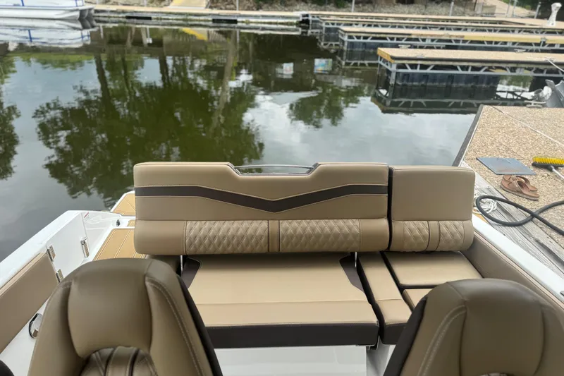 Slide: The Image of 2026 Monterey Elite 25 SD boat interior with luxurious tan seating at a dock. - 5