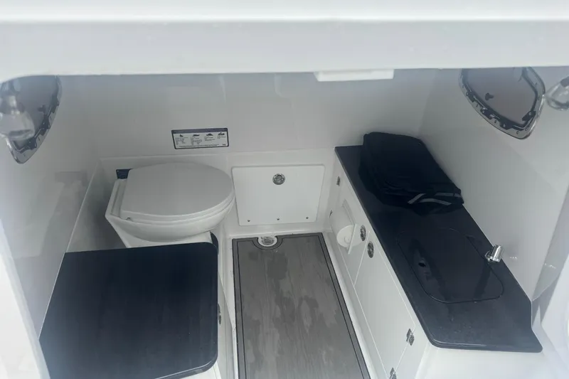 Slide: The Image of Interior of 2026 Monterey Elite 25 SD boat bathroom with toilet and sink. - 7