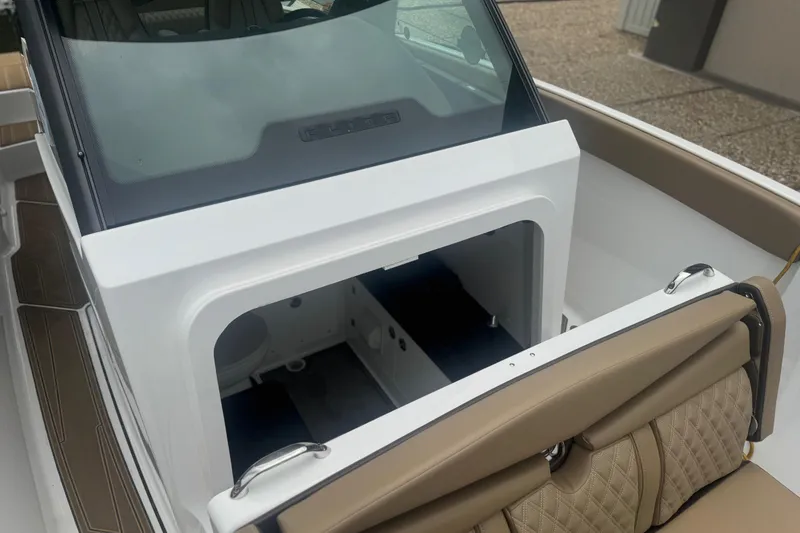 Slide: The Image of 2026 Monterey Elite 25 SD boat interior with tan seating and storage compartment. - 8