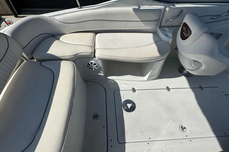 Slide: The Image of 2005 Crownline 240 EX boat interior with white seating and storage compartments. - 15