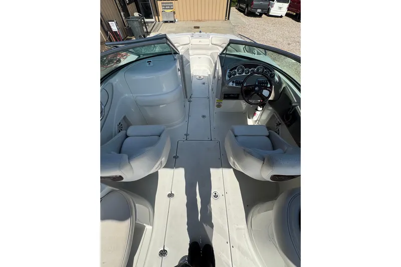 Slide: The Image of 2005 Crownline 240 EX boat interior with white seating and dashboard view. - 19