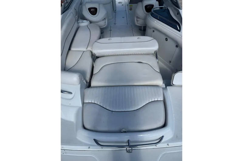 Slide: The Image of 2005 Crownline 240 EX boat interior with white cushioned seating and storage compartments. - 25
