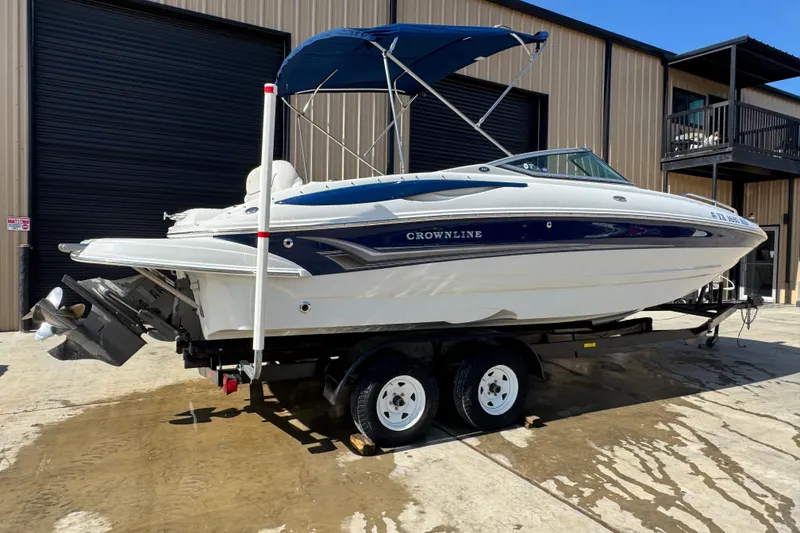Slide: The Image of 2005 Crownline 240 EX boat on trailer, parked outside a warehouse. - 7