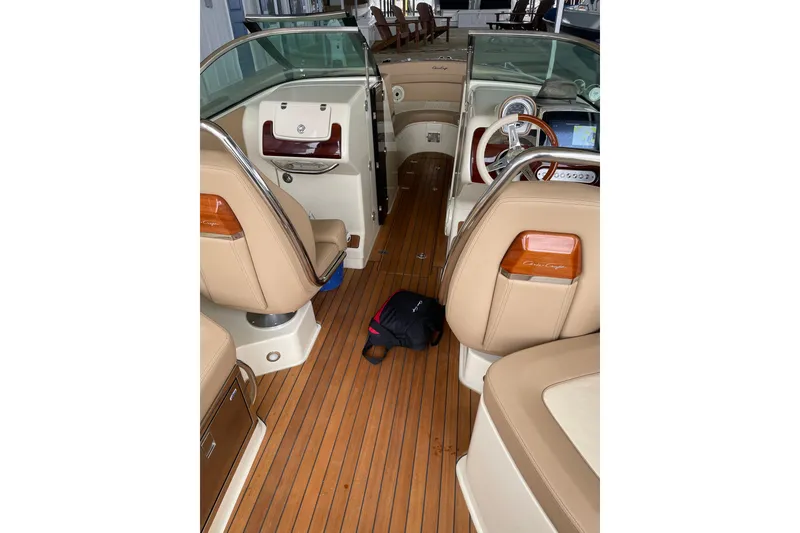 Slide: The Image of 2022 Chris Craft 28 Launch interior with tan leather seats and wooden flooring. - 2