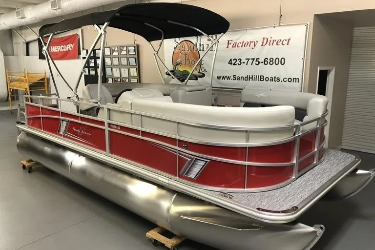The Image of 2026 SunChaser Vista 20 CRB pontoon boat with red exterior and canopy in showroom. - 0