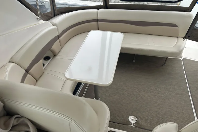 Slide: The Image of Interior seating area of 2005 Chaparral Signature 350 boat with table and cushioned seats. - 24